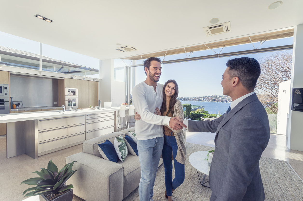 Real estate agent with couple in luxury home.